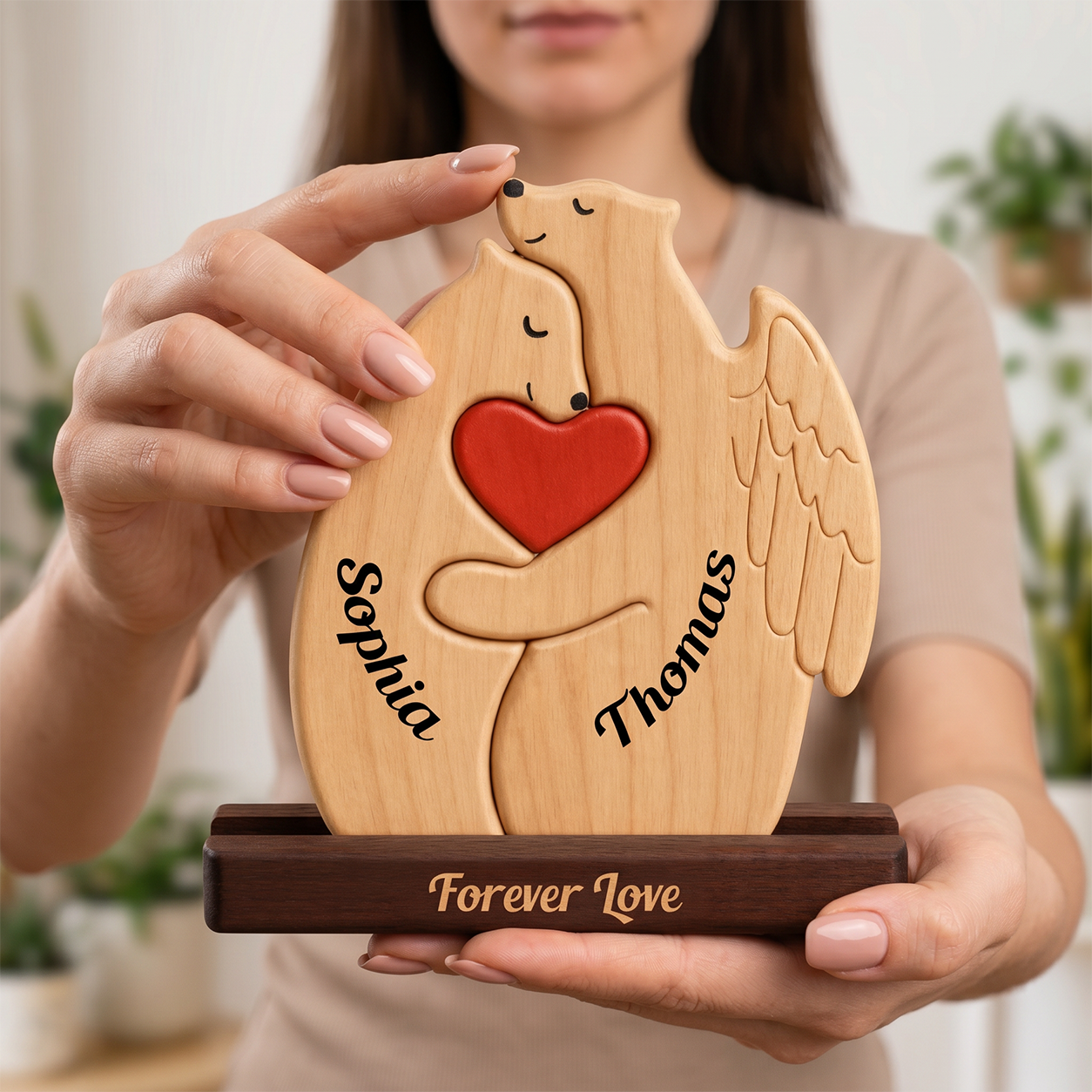 A person holds a personalized wooden dove-shaped keepsake box with two engraved hugging around a red heart, with the names and 'Forever Love' engraved on the dark wood base.