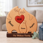 Personalized wooden cat-shaped plaque on a dark base, engraved with three smiling cats, a red heart in the center reading 2026