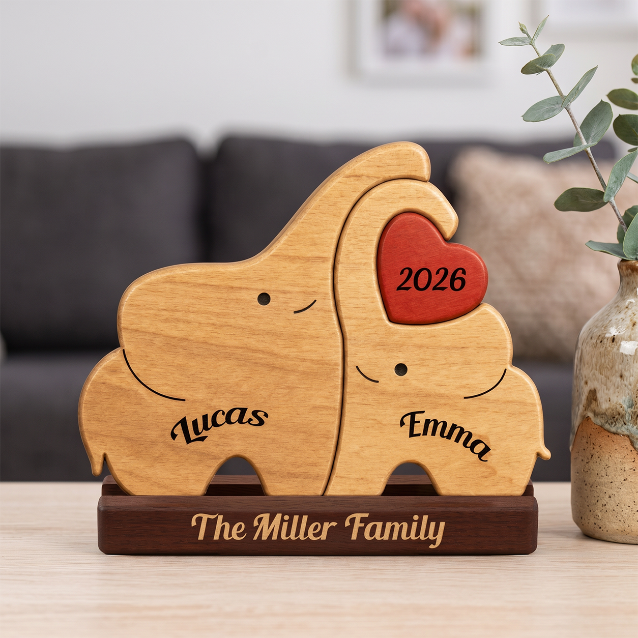 Personalized wooden elephant couple plaque on a dark base, with two light wood elephants, a red heart, and engraved names 
