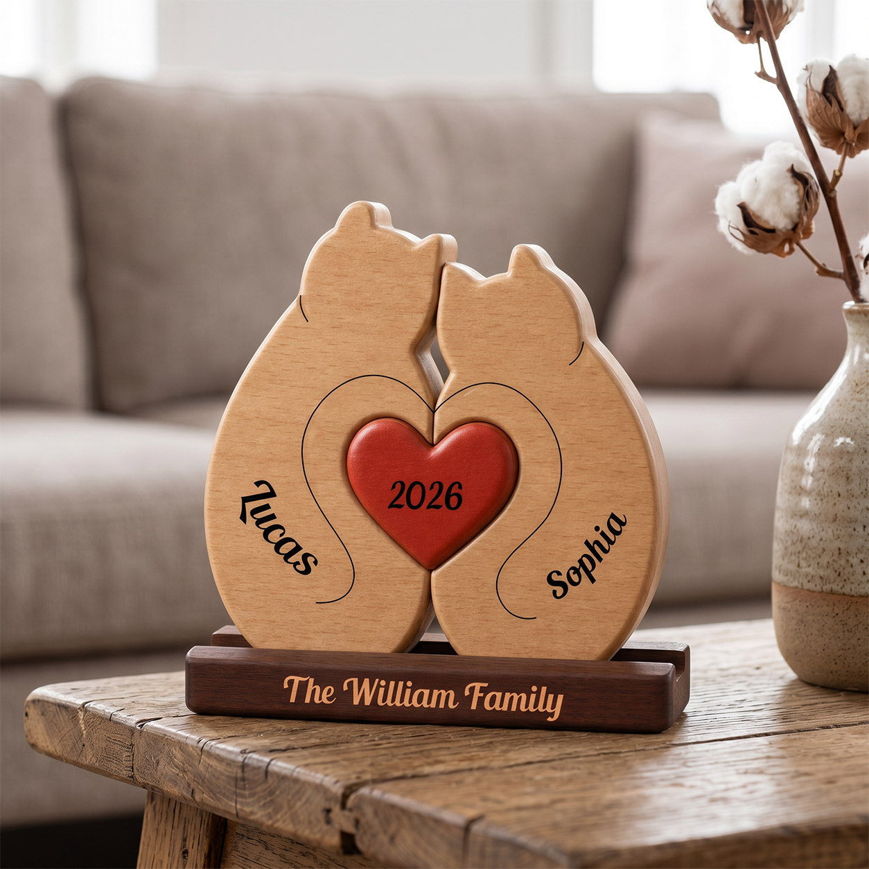 Wooden decorative piece with two cats and a heart, personalized with names and year, on a wooden table.