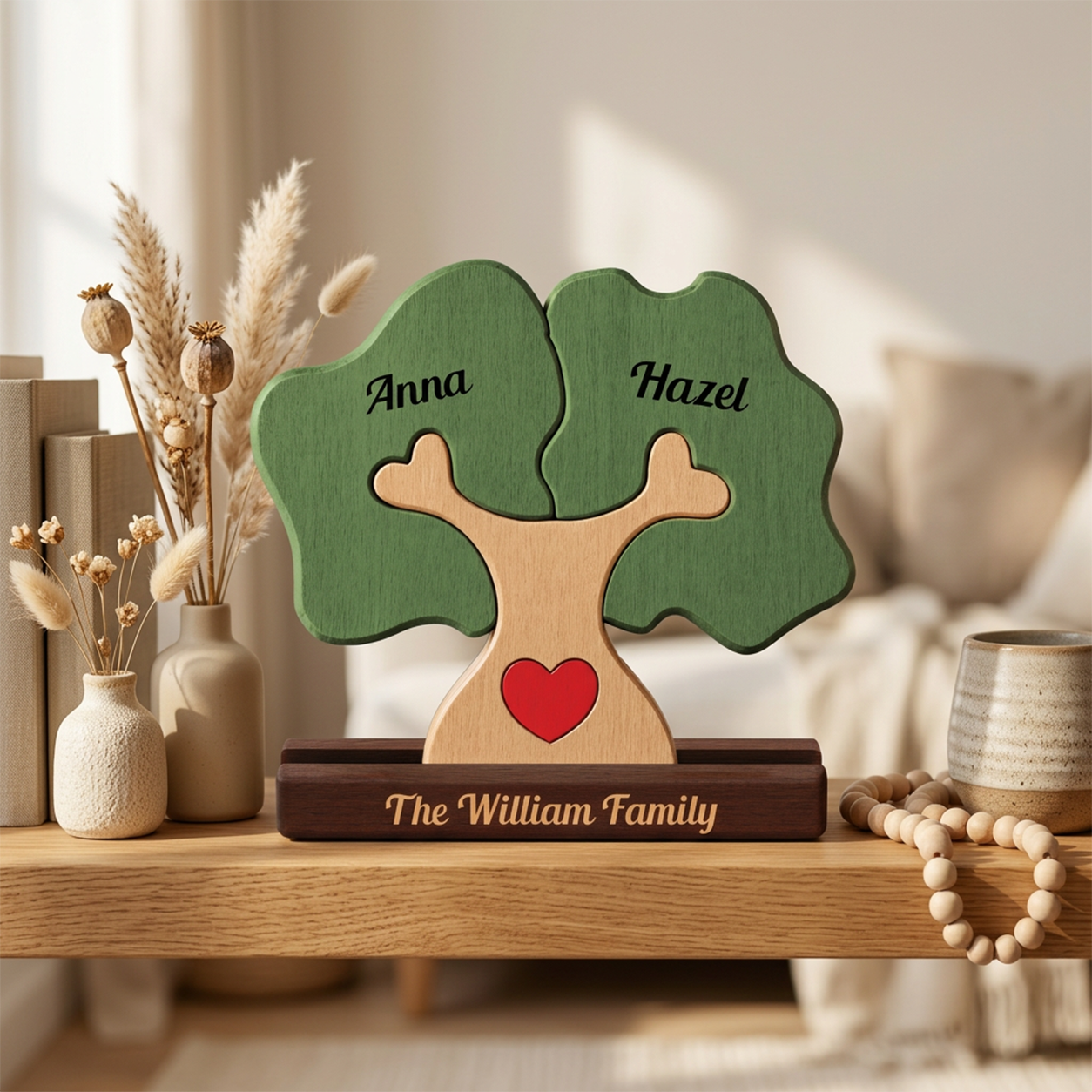 Personalized wooden family tree plaque on a dark base, with green leaves shaped like tree canopies, the names at the top, a red heart on the trunk, and the text The Family engraved on the base, styled on a wooden shelf in a warm home interior.