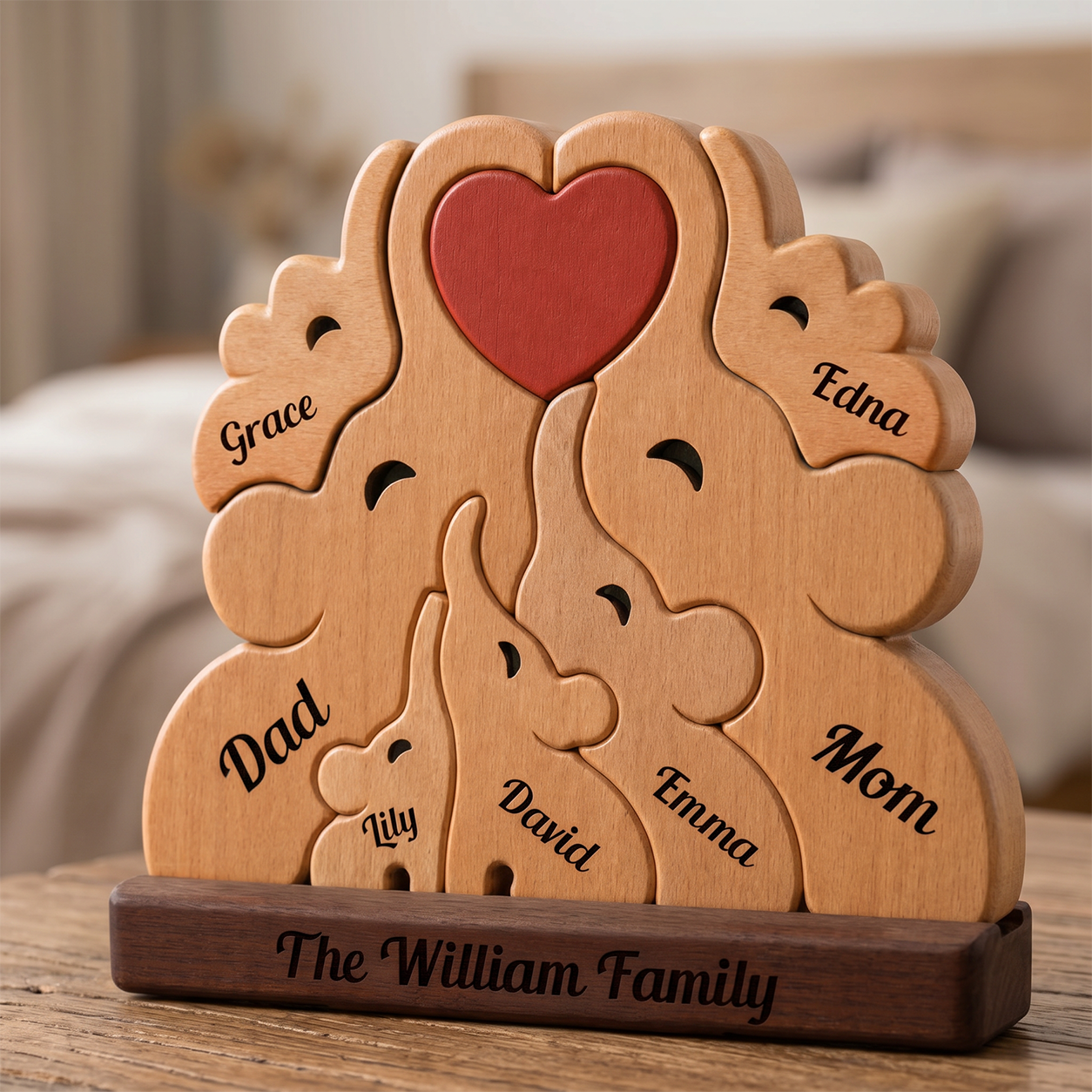 Wooden family puzzle with engraved names on a wooden base, set against a blurred indoor background.