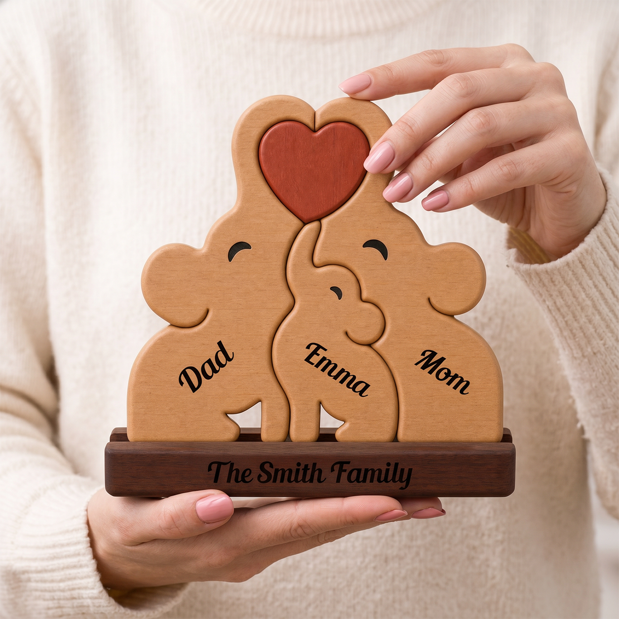 Wooden family puzzle with names, held by a person.