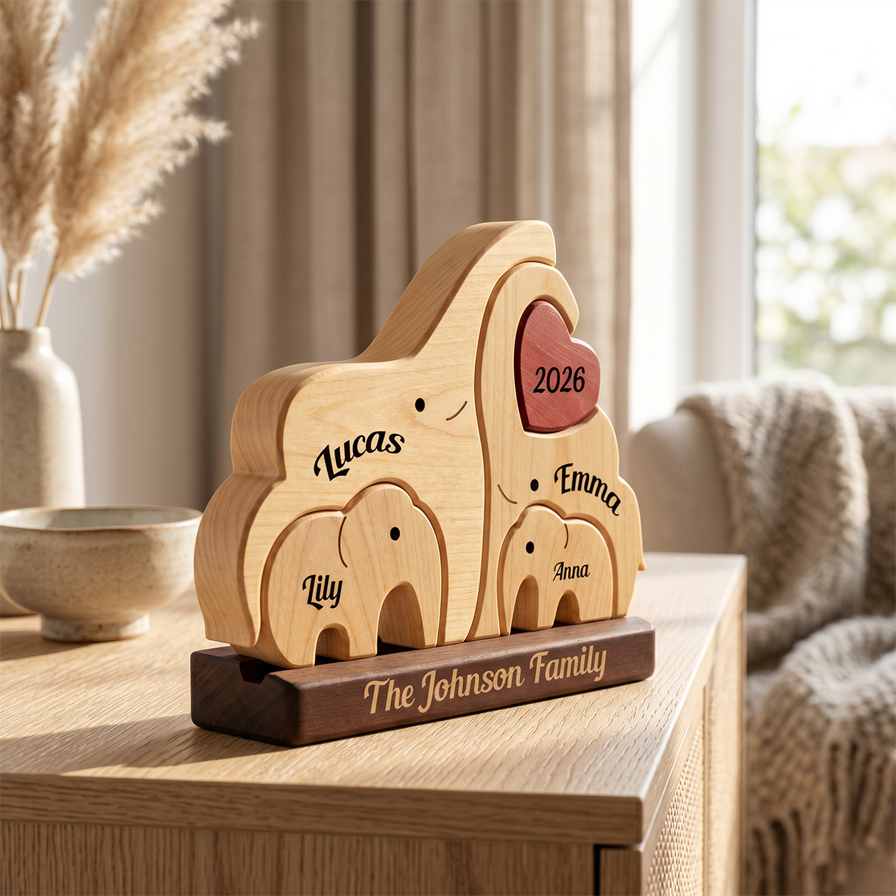 Personalized wooden family elephant plaque on a dark base, engraved with names and the year 2026, styled on a wooden table in a warm living room setting.