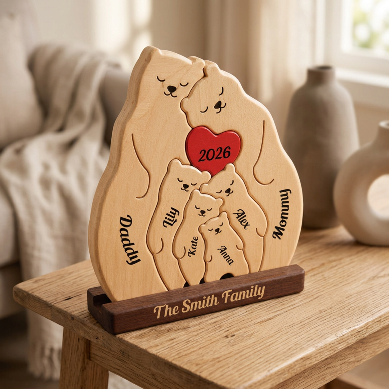Personalized wooden family puzzle plaque shaped like a bear family, displayed on a wooden stand on a table in a softly lit room. The light wood puzzle shows engraved family names 
