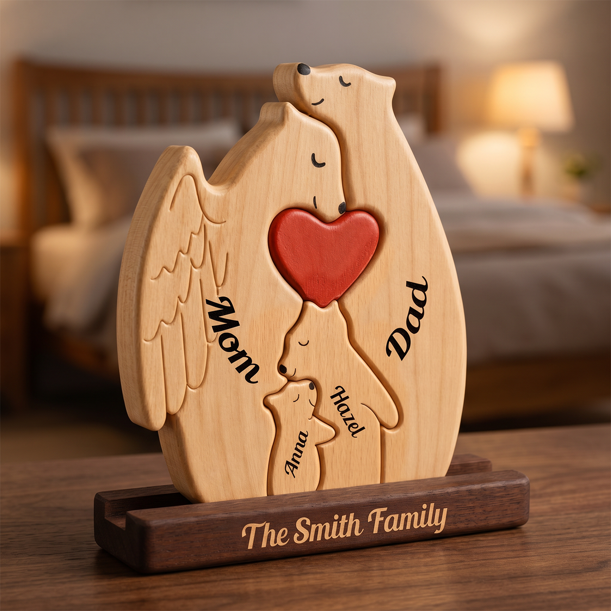 Personalized wooden memorial plaque shaped, engraved with names, holding a red heart, displayed on a dark wooden base engraved with 'The Family name' in a warm bedroom setting.