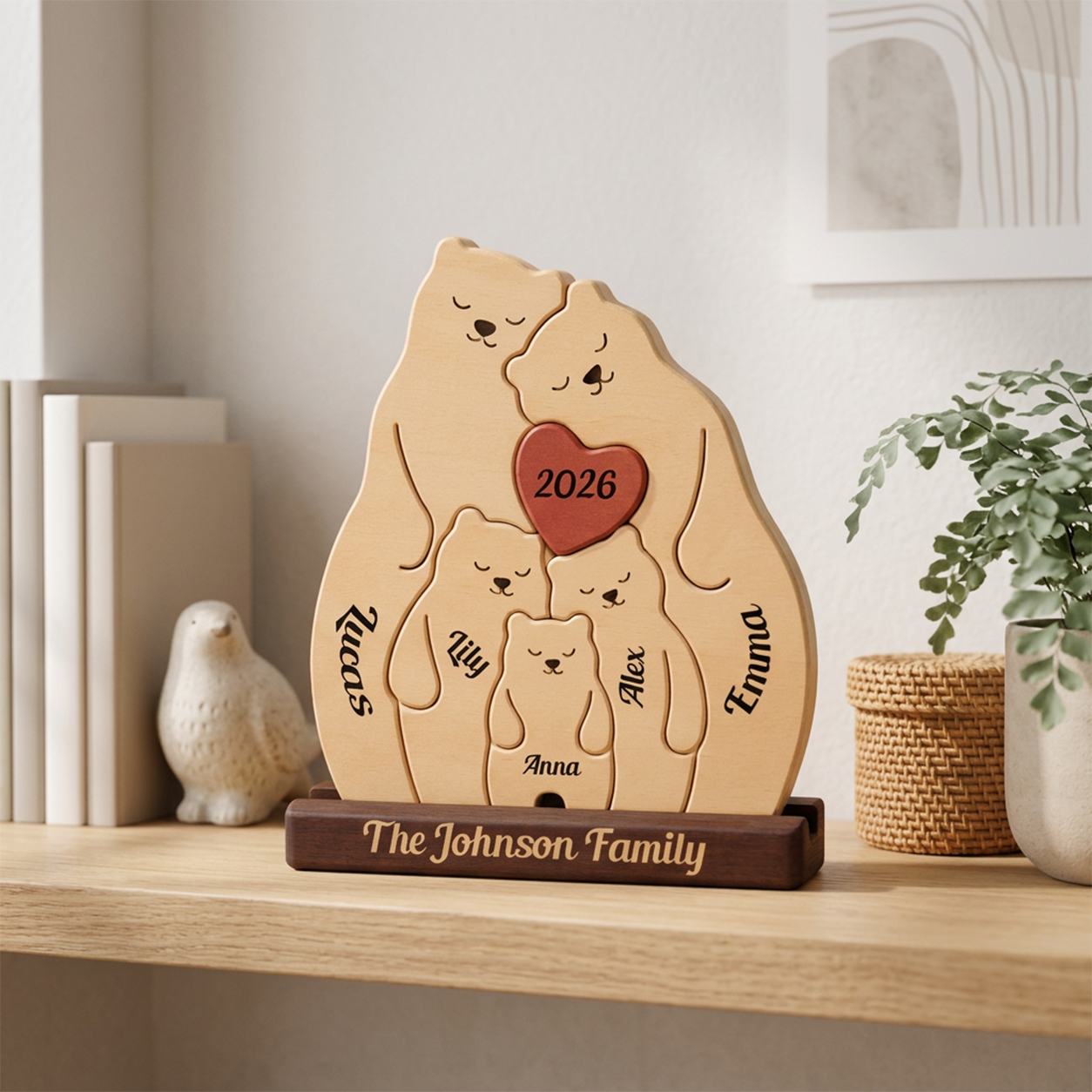Personalized wooden family bear Uv print with names and a red heart reading 2026, displayed on a wooden shelf in a home interior setting.