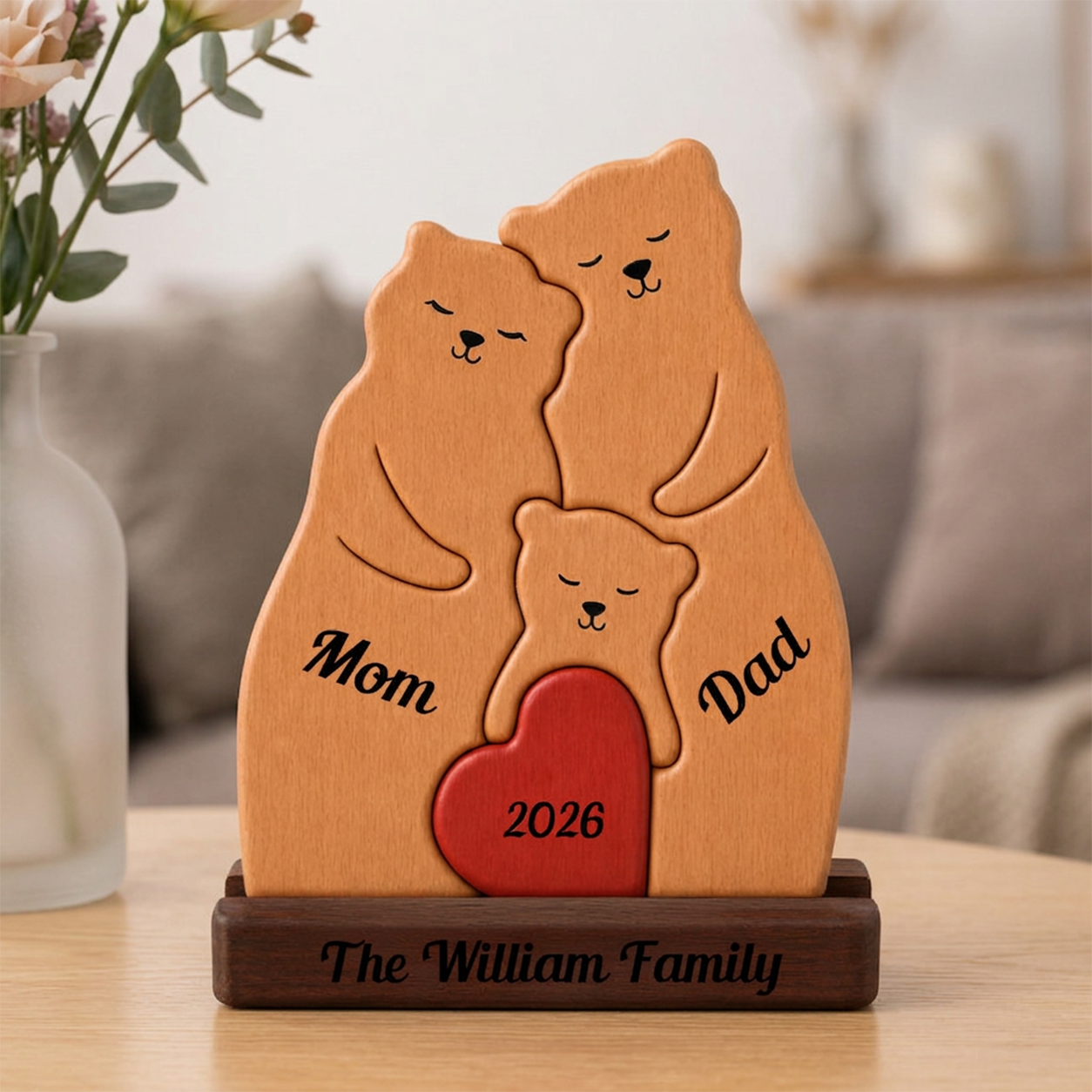 Wooden plaque with bear family design, 'Mom', 'Dad', '2026', and 'The Family' text on a blurred background.