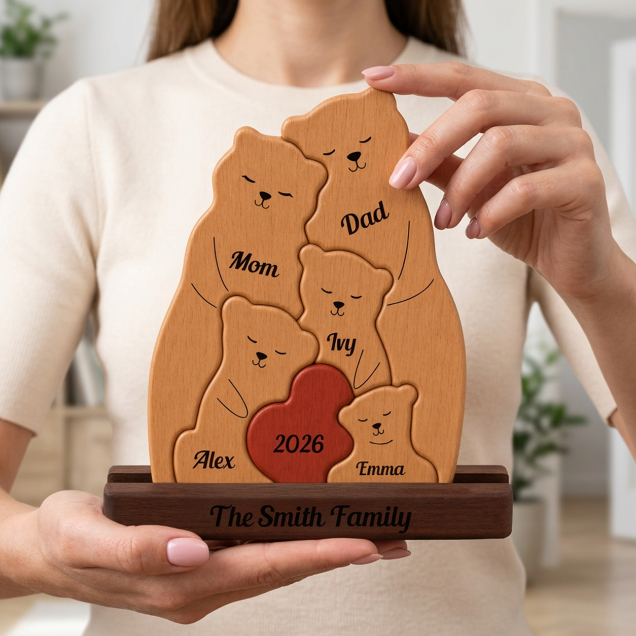 Wooden family plaque with engraved names held by a person indoors.