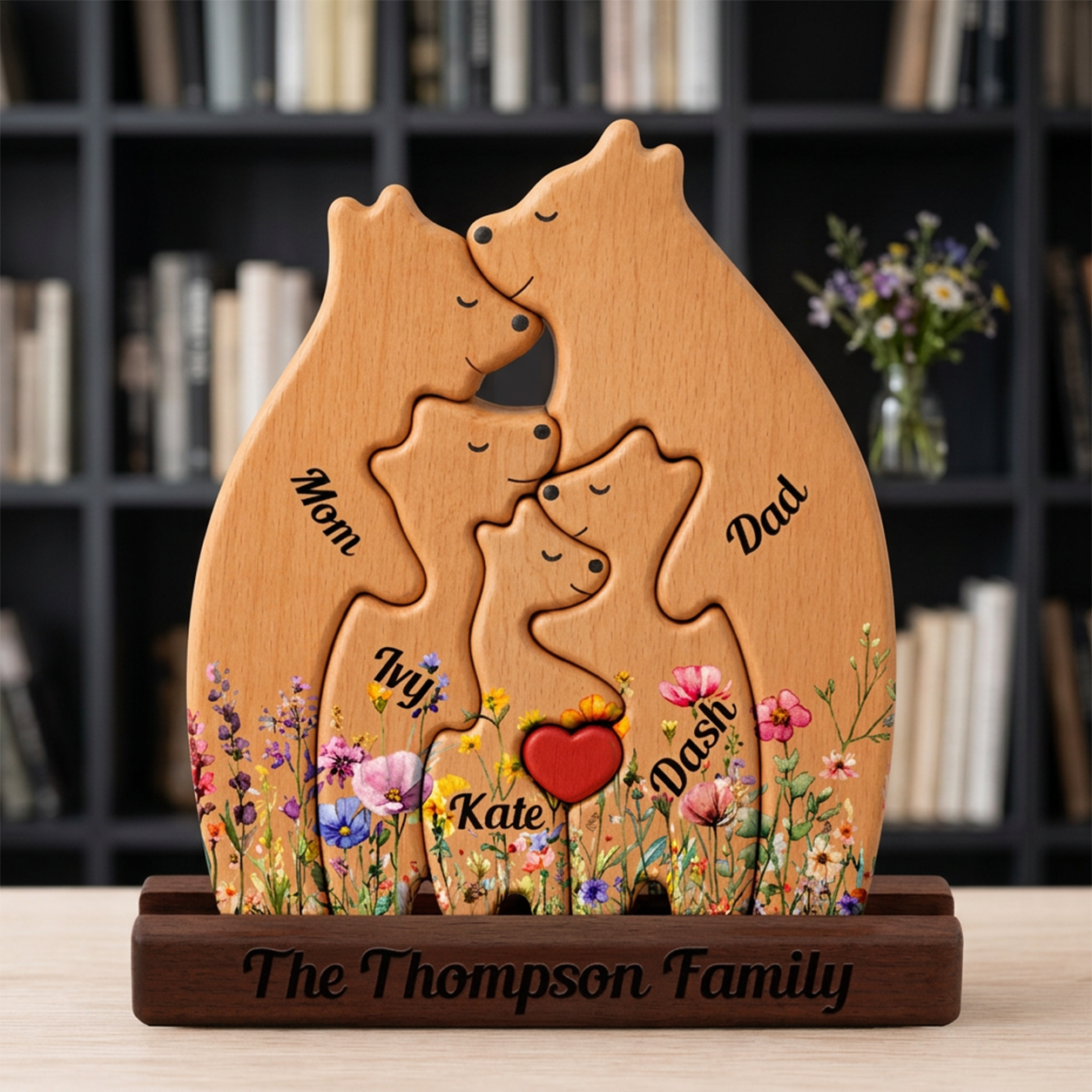 Wooden family sculpture with engraved names in front of a bookshelf
