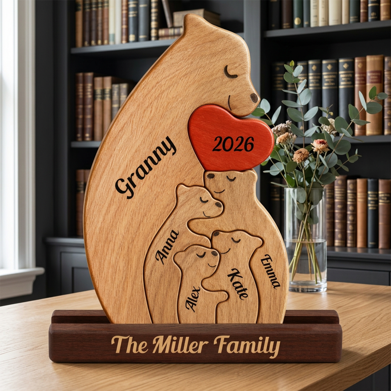 Wooden family plaque with engraved names and year, placed on a table with a bookshelf in the background.