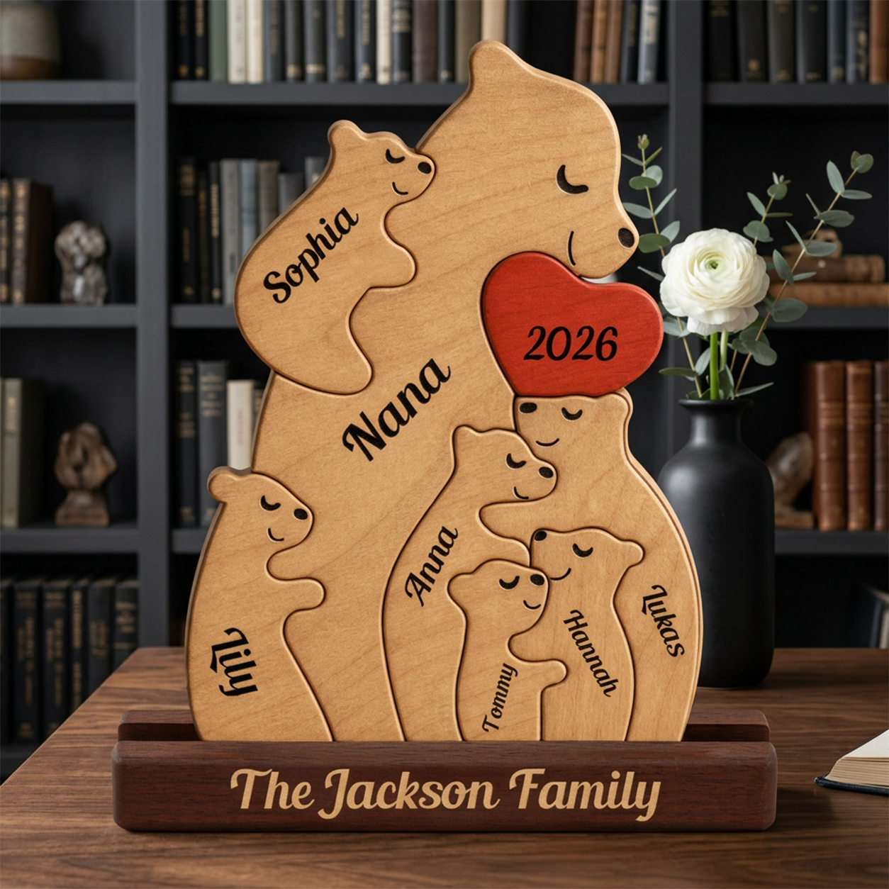 Wooden family plaque with engraved names and year, displayed on a table with a bookshelf background.