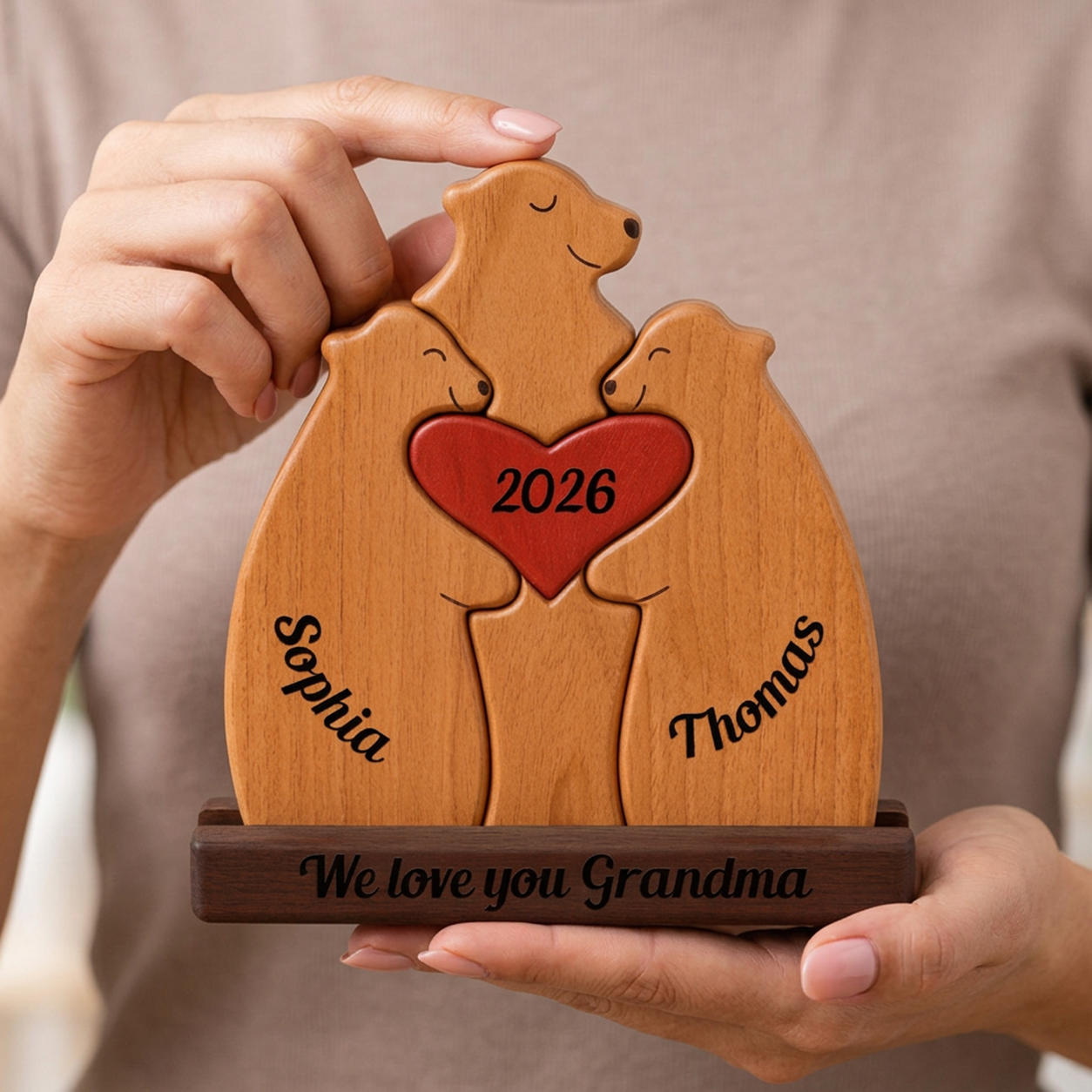 Wooden plaque with engraved names and year, held by a person