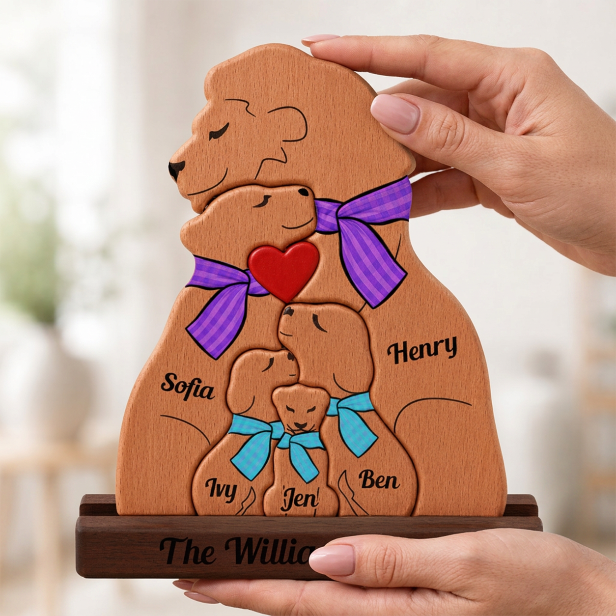 Wooden family portrait with four bears wearing colorful bows, held by a hand.