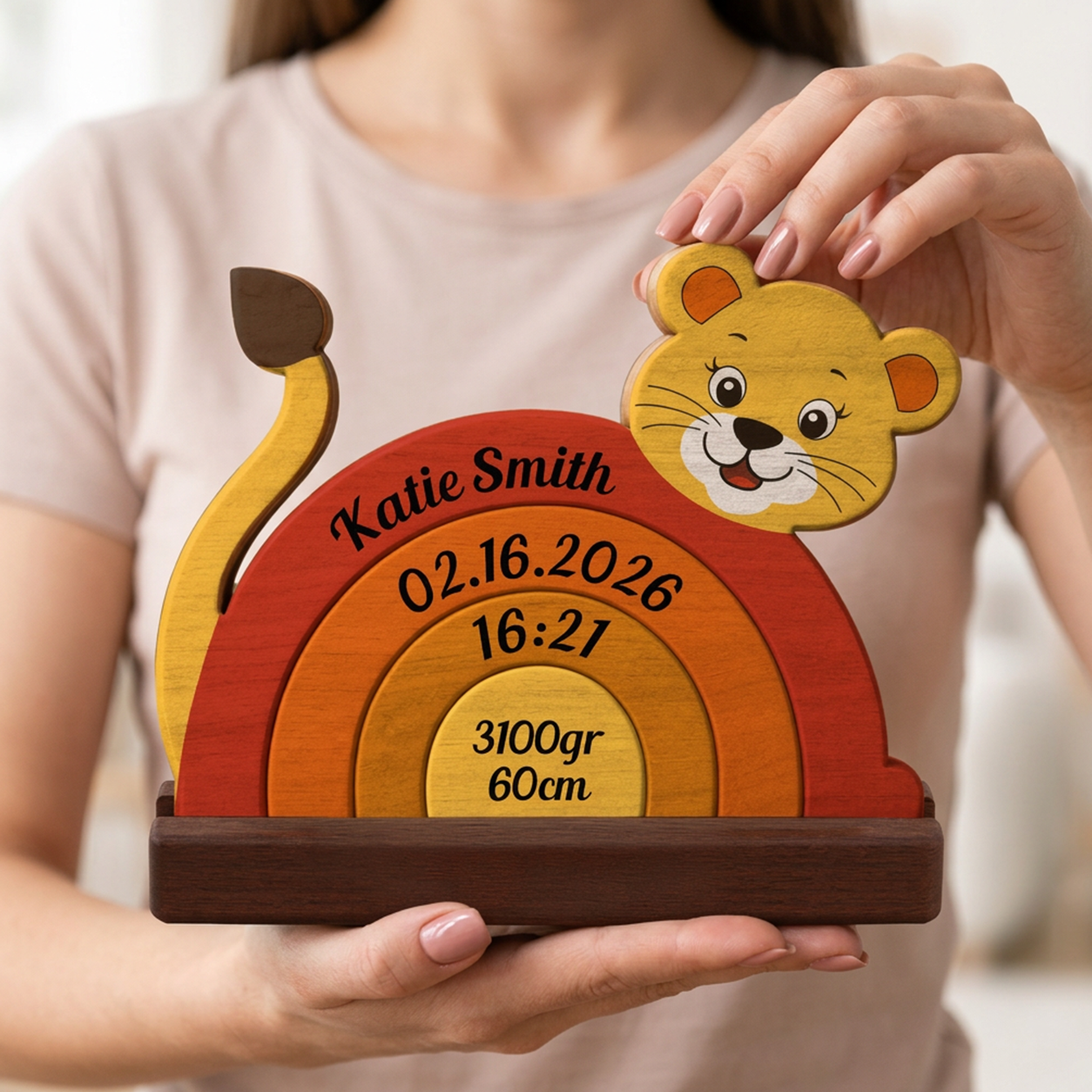 Wooden baby milestone plaque with lion design held by a person