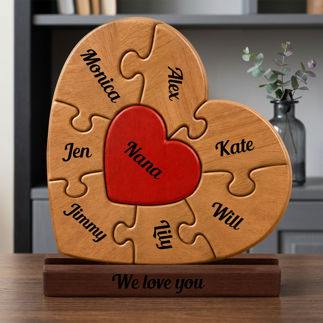 Wooden heart-shaped puzzle with engraved names and a red heart in the center, placed on a wooden stand.