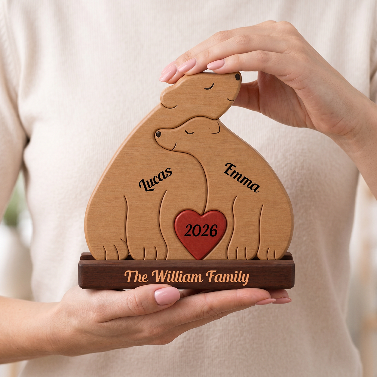 Wooden two bears and a heart, personalized with names and year, held by hands against a neutral background.