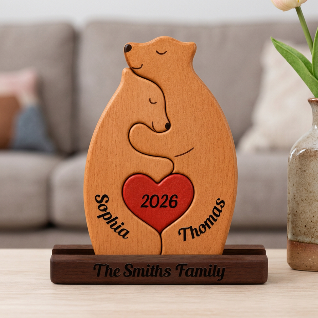 Wooden couple bears holding a heart, engraved with names and year, on a wooden stand.