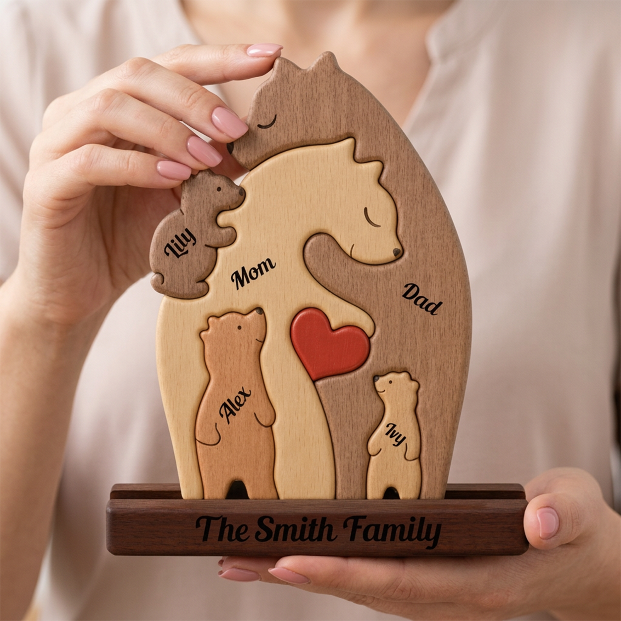 Wooden family portrait with engraved names held by a person