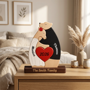 Personalized wooden bear sculpture on a dark wooden base, displayed on a bedside table in a softly lit bedroom. 